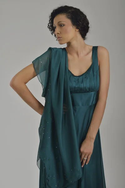 Elegant kvinna i fashionabla klänning poserar i studion — Stockfoto