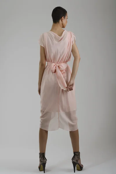 Elegáns nő divatos ruhában pózol a stúdió — Stock Fotó
