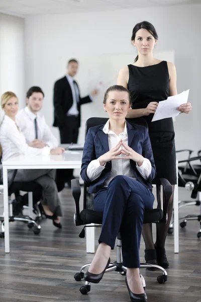 Affärskvinna med hennes personal i bakgrunden — Stockfoto