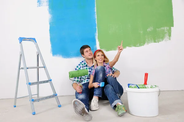 Feliz joven pareja relajante después de pintar en un nuevo hogar — Foto de Stock
