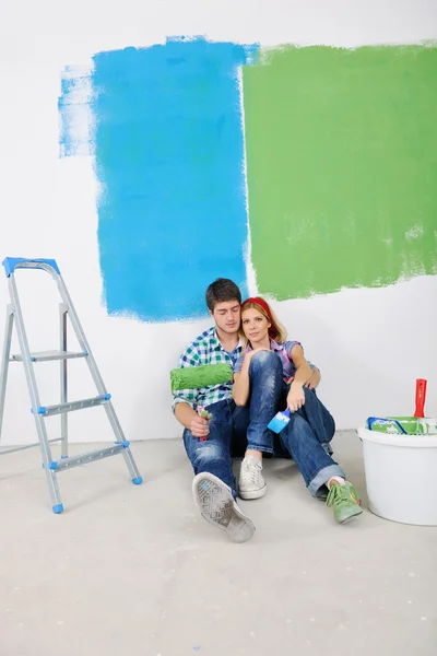 Feliz joven pareja relajante después de pintar en un nuevo hogar —  Fotos de Stock