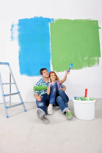 Feliz joven pareja relajante después de pintar en un nuevo hogar —  Fotos de Stock
