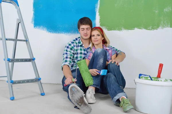 Parede de pintura casal feliz na nova casa — Fotografia de Stock