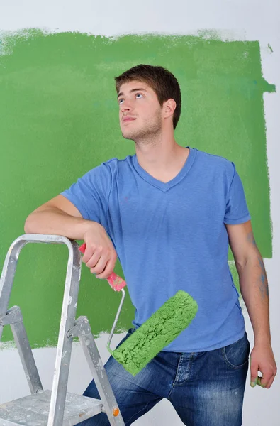 英俊的年轻男子油漆的颜色在白墙 — 图库照片