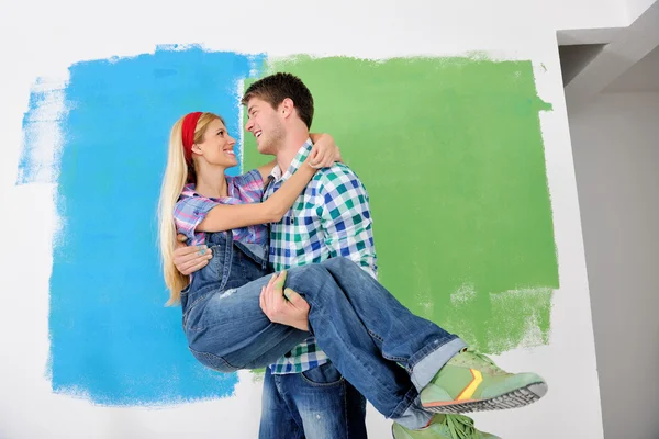 Feliz pareja pintura pared en nuevo hogar —  Fotos de Stock