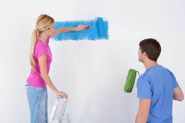 Stock image Happy couple paint wall at new home