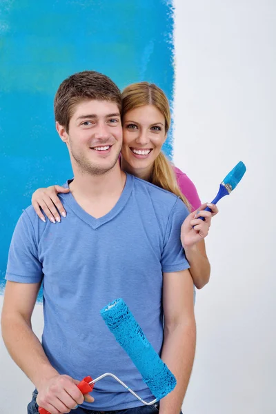 Feliz pareja pintura pared en nuevo hogar — Foto de Stock