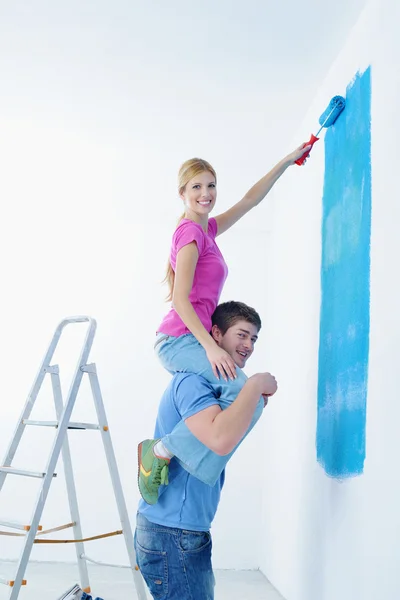 Stock image Happy couple paint wall at new home