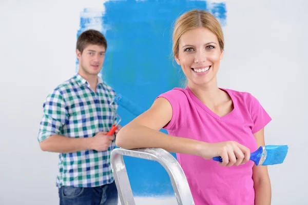 stock image Happy couple paint wall at new home