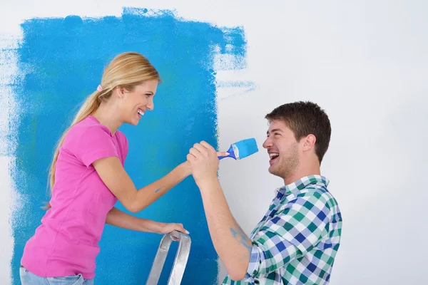 Feliz pareja pintura pared en nuevo hogar — Foto de Stock
