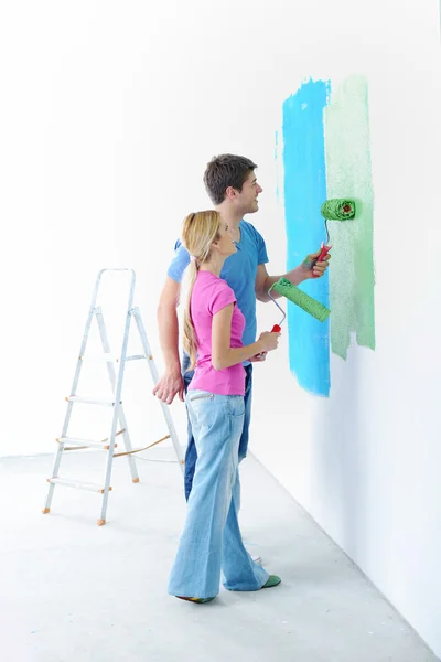 Feliz pareja pintura pared en nuevo hogar —  Fotos de Stock