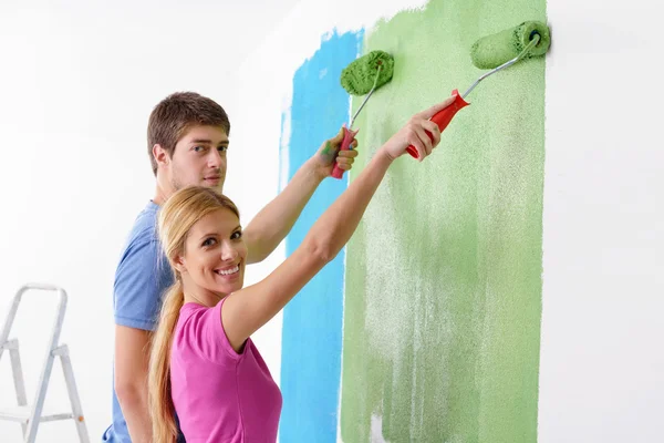 Šťastný pár malovat stěnu v novém domově — Stock fotografie