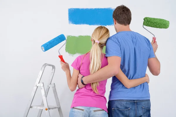 Szczęśliwy para farby ściany w nowym domu Obrazek Stockowy