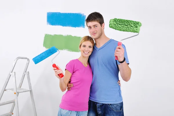 Щаслива пара фарбує стіну в новому будинку — стокове фото