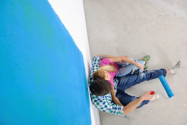 Gelukkige jongeren ontspannen na het schilderen in een nieuw huis — Stockfoto
