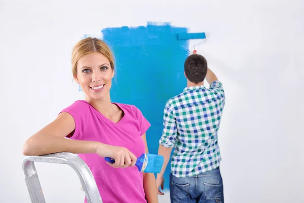 Szczęśliwy para farby ściany w nowym domu — Zdjęcie stockowe