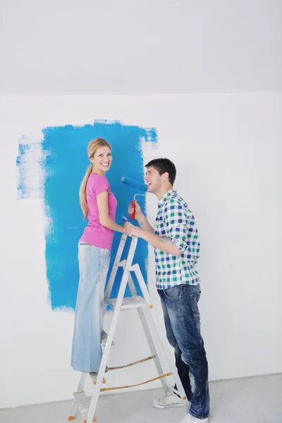 Šťastný pár malovat stěnu v novém domově — Stock fotografie