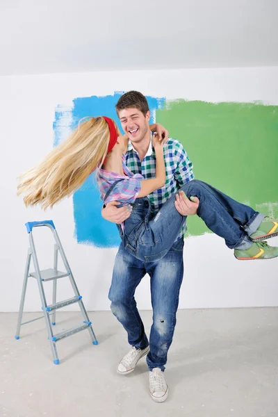 Счастливая пара покрасит стену в новом доме — стоковое фото