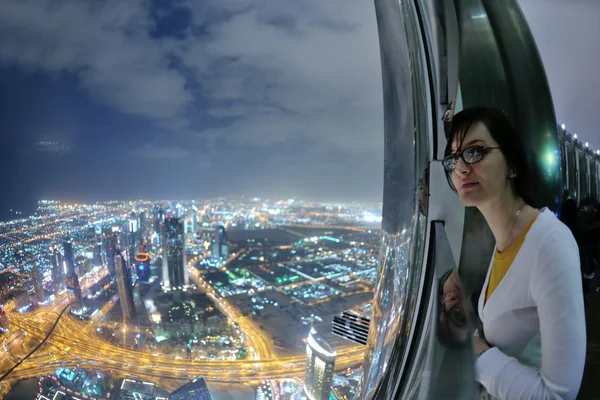Mooie vrouw portret met grote stad bij nacht in achtergrond — Stockfoto