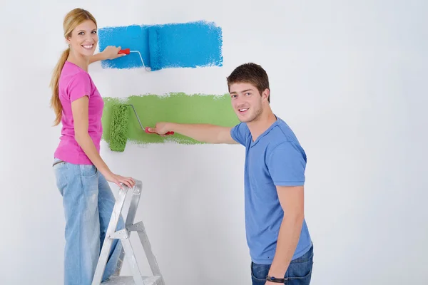 Parede de pintura casal feliz na nova casa — Fotografia de Stock