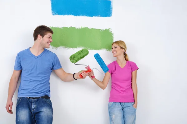 Счастливая пара покрасит стену в новом доме Лицензионные Стоковые Фото