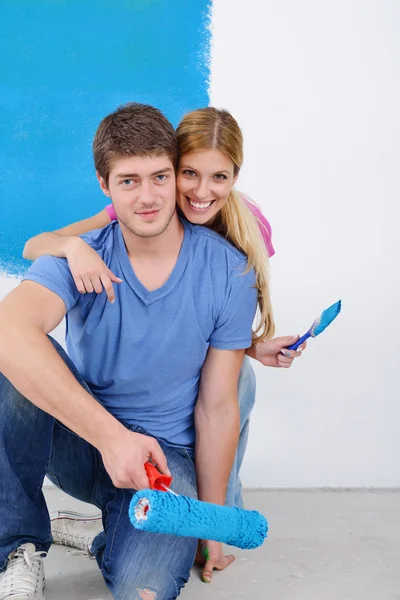 Parede de pintura casal feliz na nova casa — Fotografia de Stock