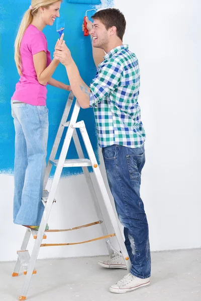 Χαρούμενο ζευγάρι ζωγραφίζει τοίχο στο νέο σπίτι — Φωτογραφία Αρχείου
