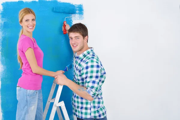Feliz pareja pintura pared en nuevo hogar — Foto de Stock