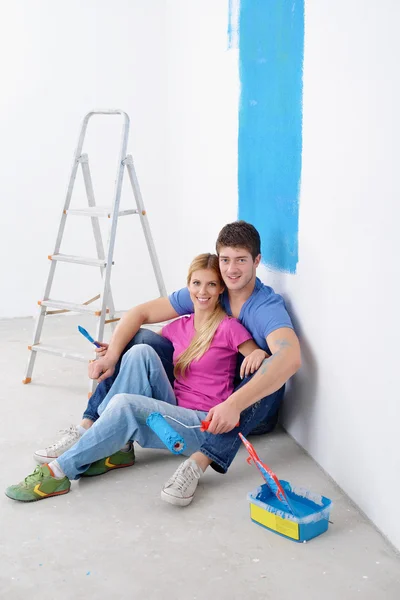 Feliz joven pareja relajante después de pintar en un nuevo hogar — Foto de Stock