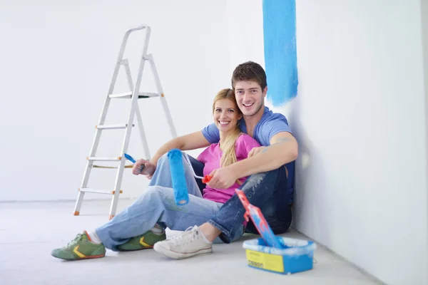 Feliz joven pareja relajante después de pintar en un nuevo hogar — Foto de Stock