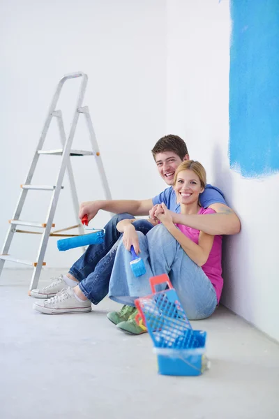 Feliz joven pareja relajante después de pintar en un nuevo hogar — Foto de Stock