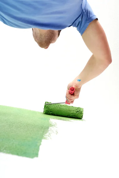 Knappe jonge man verf witte muur in kleur — Stockfoto