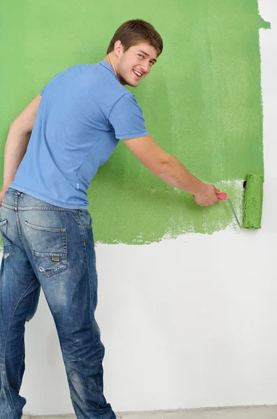 Stilig ung man måla vit vägg färg — Stockfoto