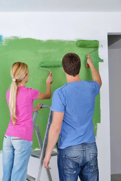 Happy couple paint wall at new home — Stock Photo, Image