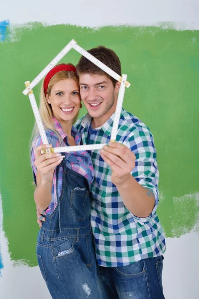 Lykkelige par maling væg på nyt hjem - Stock-foto