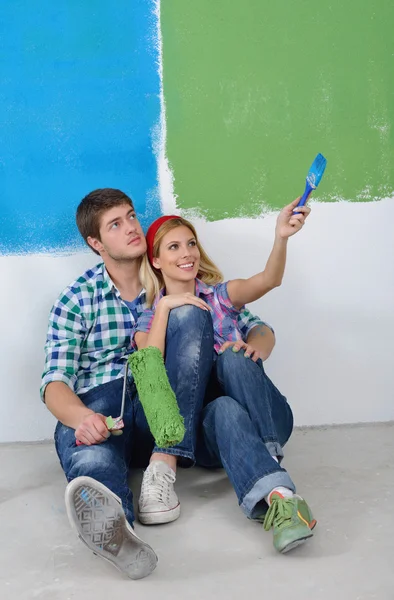 Feliz pareja pintura pared en nuevo hogar —  Fotos de Stock