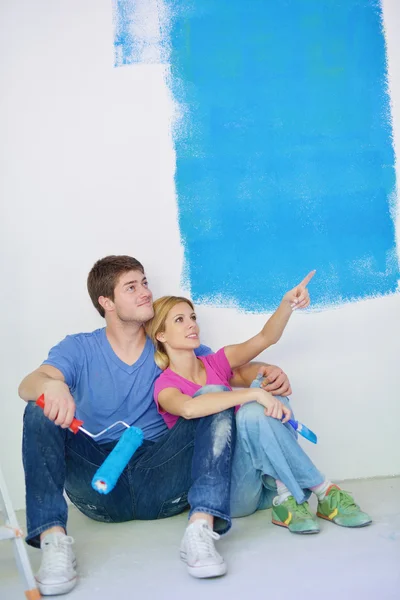 Jovem cople feliz relaxante depois de pintar em nova casa Imagem De Stock