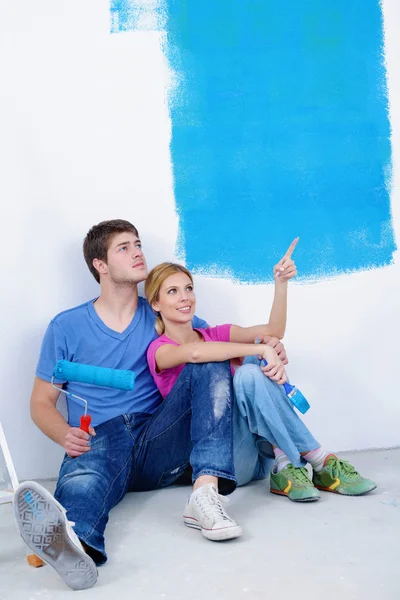 Jovem cople feliz relaxante depois de pintar em nova casa Imagem De Stock