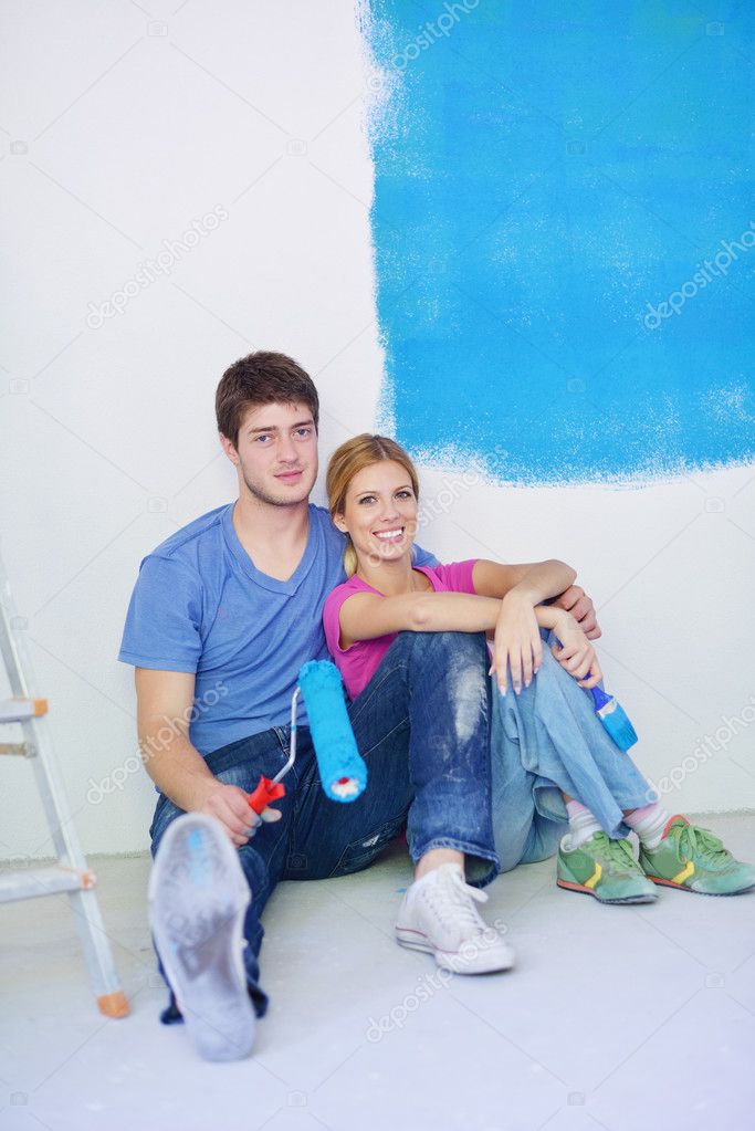 Happy young cople relaxing after painting in new home