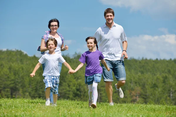 Щаслива молода сім'я розважається на відкритому повітрі — стокове фото