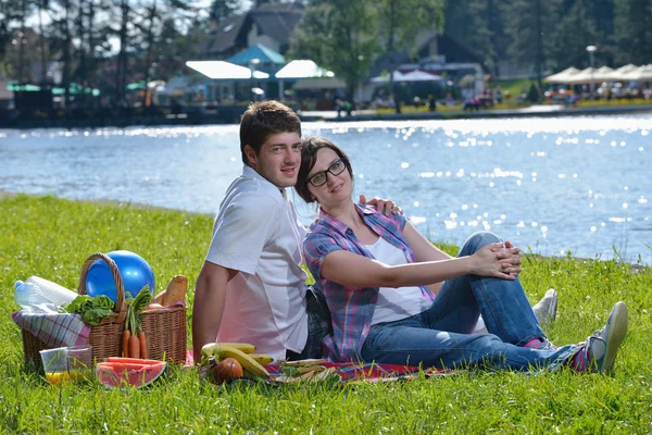 Happy νεαρό ζευγάρι που έχοντας ένα πικνίκ, υπαίθρια — Φωτογραφία Αρχείου