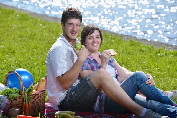 Happy young couple having a picnic outdoor — Stok fotoğraf