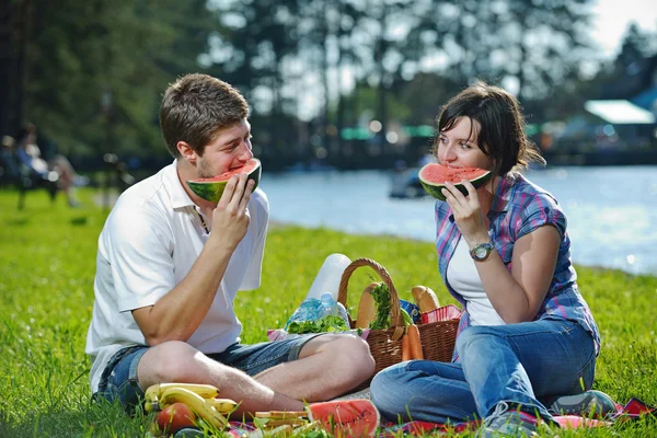 Feliz pareja joven teniendo un picnic al aire libre — Foto de Stock