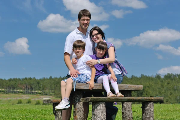 幸せな若い家族が屋外に楽しい時を過す — Stock fotografie