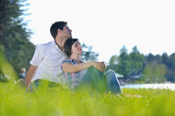 Счастливая молодая пара устраивает пикник на открытом воздухе — стоковое фото