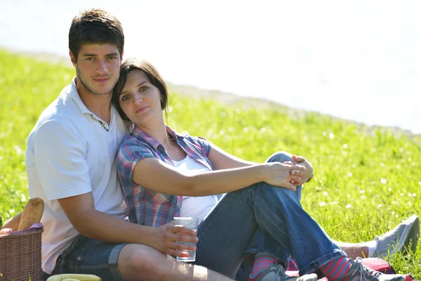 Lyckliga unga paret har picknick utomhus Stockfoto