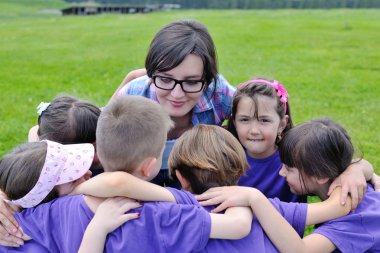 Happy kids group with teacher in nature clipart