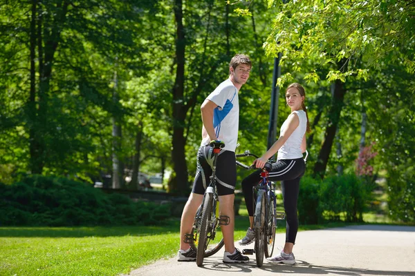 Happy couple riding bicycle outdoors — Stock Photo, Image