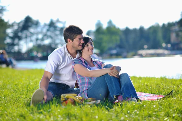 Et lykkelig ungt par som har piknik utendørs – stockfoto