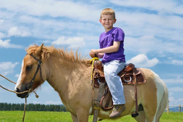 Dítě jezdit poníka — Stock fotografie